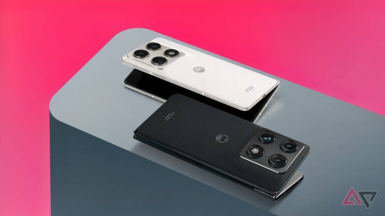 two-motorola-razr-fold-smartphones-one-in-lily-white-and-one-in-blackened-blue-resting-on-a-grey-sur.jpeg
