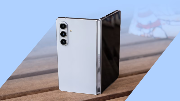 a-silver-samsung-galaxy-z-fold-phone-stands-partially-open-on-a-wooden-table.png