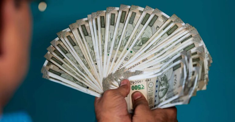 indian-male-hand-holding-five-hundred-notes-currency-shutterstock-com.jpg