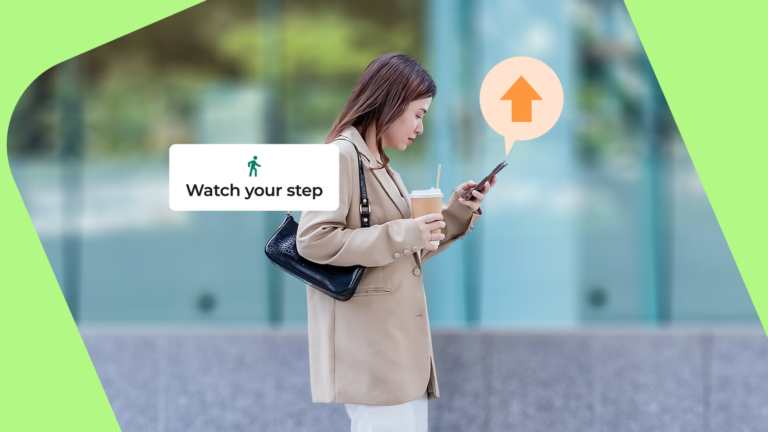 woman-looking-at-her-phone-as-a-heads-up-alert-reminds-her-to-watch-her-step.png
